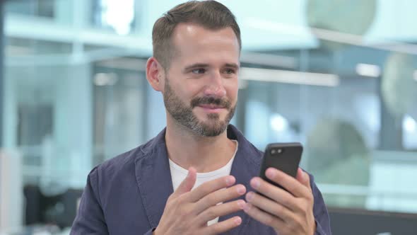 Middle Aged Businessman Celebrating on Smartphone