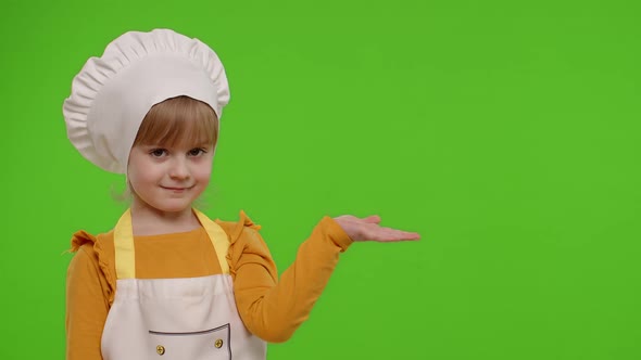 Child Girl Dressed Like Chef Cook Pointing at Right on Blank Space Place for your Advertisement Logo