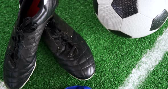 Football, medal and cleats on artificial grass 4k