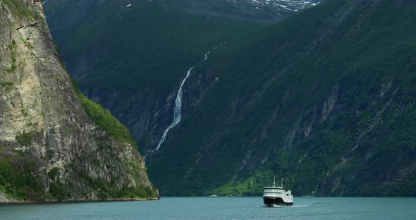 Geirangerfjord, Norway. Touristic Ship Ferry Boat Floating Liner Through Waters Of Geirangerfjorden