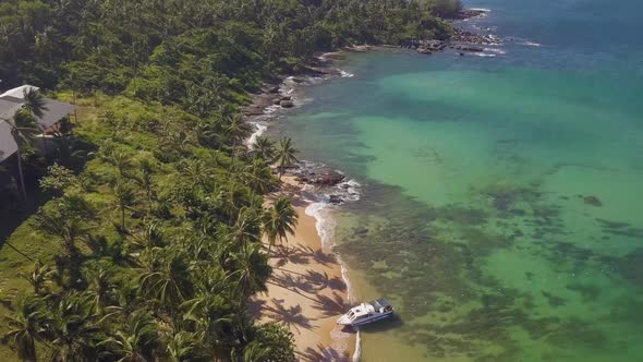 Aerial View at a Scenic Island with Blue Water Beach Sorrounded with Palm Trees.