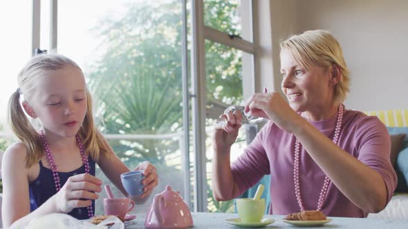 Side view of Caucasian woman playing with her daughter at home