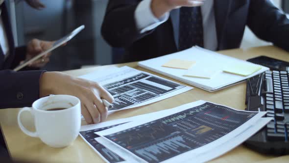 Couple of Traders Studying Financial Charts on Papers