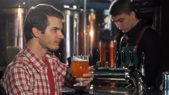 Happy Young Man Enjoying Resting at the Pub Sipping Delicious Beer