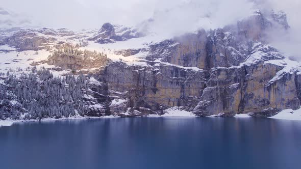 Oeschinen Lake in Switzerland Surrounded by Snow Covered Forests and Mountains