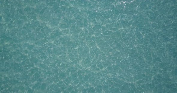 Wide drone clean view of a sunshine white sandy paradise beach and aqua blue ocean background 