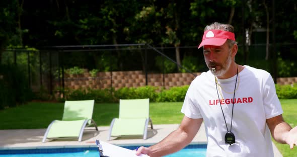 Lifeguard holding clipboard and whistling