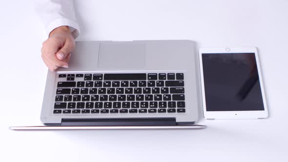 Girl Makes a Online Shopping Using Notebook and Laptop in the Office. Close Up