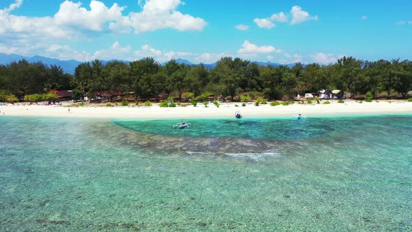 Coral reef barrier bordering calm clear water of turquoise lagoon washing white sand of exotic beach