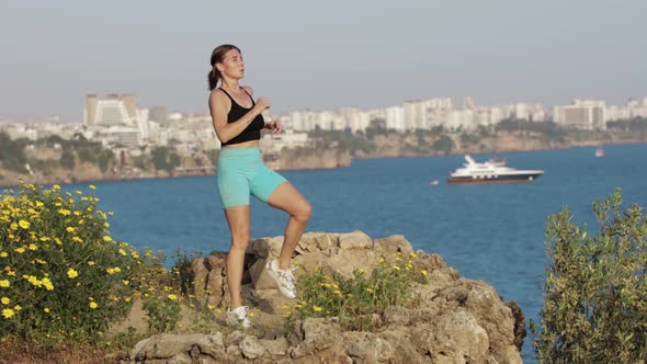 Sports Outdoors  a Woman Doing Fitness Exercises on the Spot on the Hill By the Sea