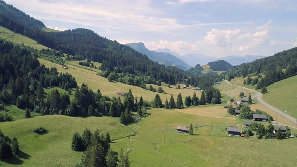 Aerial View of a Valley in Switzerland with Chalets and a Mountainous Landscape