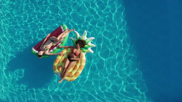 Aerial View of Young Women Floating in Pool