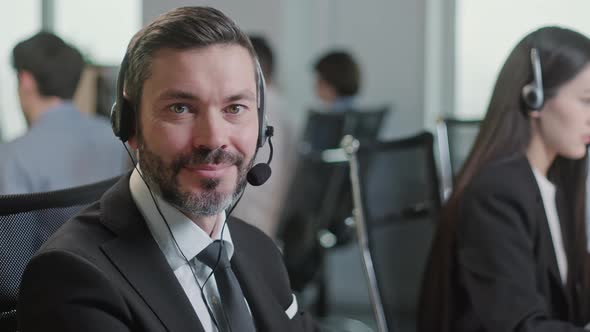 Portrait of Handsome Happy and Man Smiling and Looking at Camera While Working in Call Center