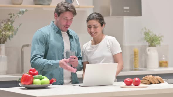 Mixed Race Couple Doing Video Call on Laptop in Kitchen