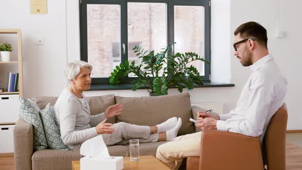 Psychologist Giving Glass of Water To Senior Woman