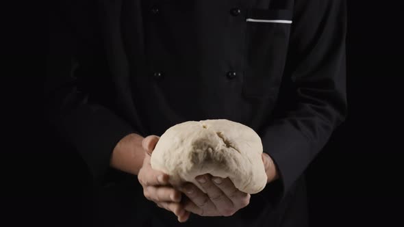 A Baker Forms a Glob of Dough Holding It in His Hands