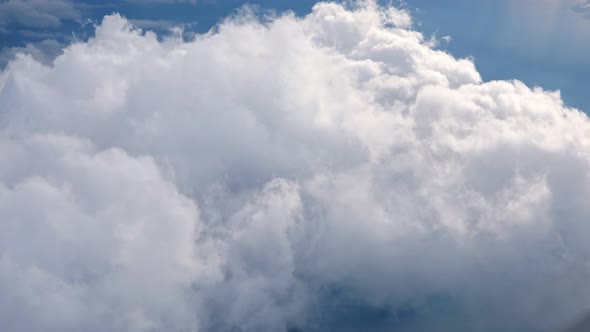 White Soft Fluffy Clouds Over the Green Landscape Aerial View From the Plane