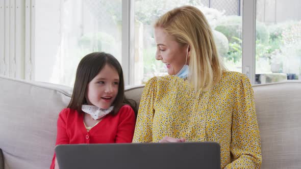 Mother and daughter having a video chat on laptop at home