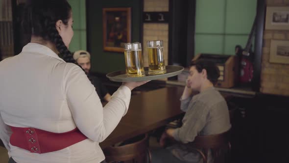 Pretty Plump Fat Girl with Three Glasses of Beer on a Tray in a Beer Restaurant