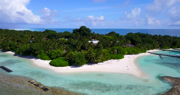 Tropical fly over travel shot of a sandy white paradise beach and aqua turquoise water background in