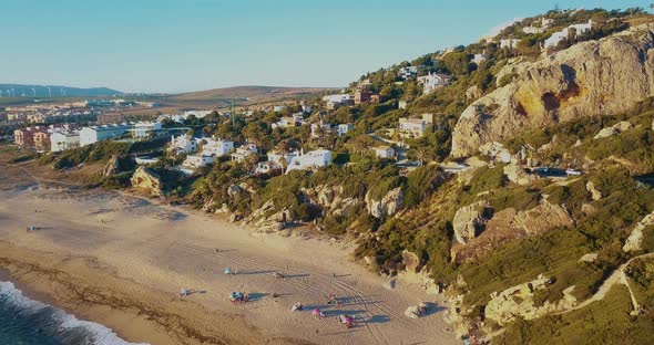 Aerial view of the coast of the south of Spain. Big rock with luxury houses and windmills in the hor