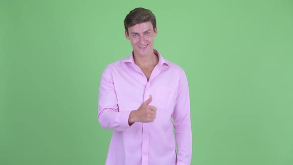 Happy Young Handsome Businessman Giving Thumbs Up