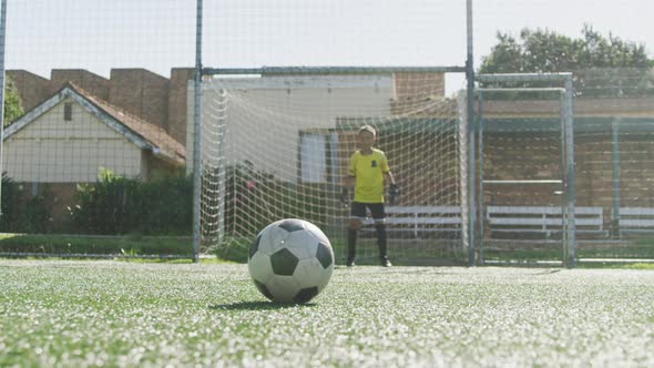 African American soccer kid in blue scoring in a sunny day