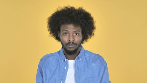 Sad Upset AfroAmerican Man on Yellow Background