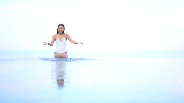 Young asian woman enjoy around outdoor swimming pool for leisure