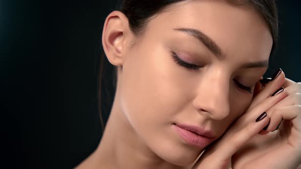 Closeup Asian Brunette Woman Face with Hazel Eyes Touching Fresh Perfect Skin Posing Isolated Black