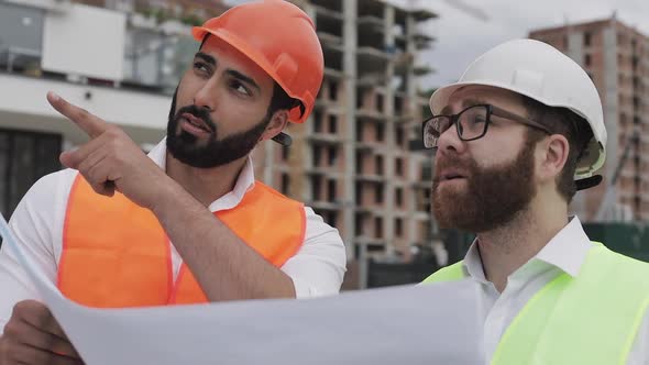 Architect Expert Engineers Talking and Analyze Design Plan Standing Under Construction Site