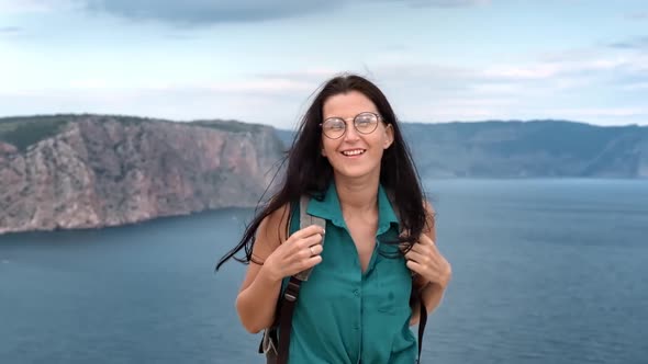 Portrait of Happy Woman Rejoicing Posing on Top of Mountain Over Sea