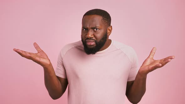 African American Man Raising His Hands Waiting for Excusement Pink Studio Background