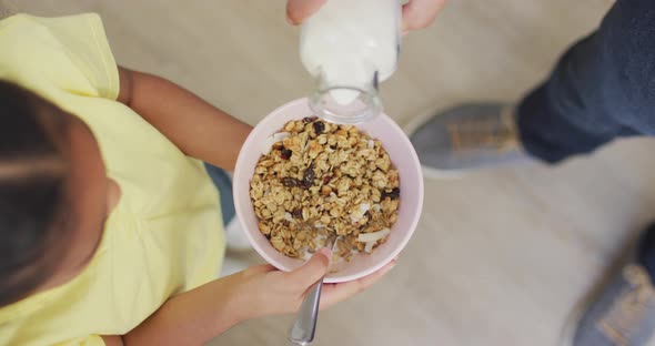 Happy biracial father and daughter preparing breakfast together