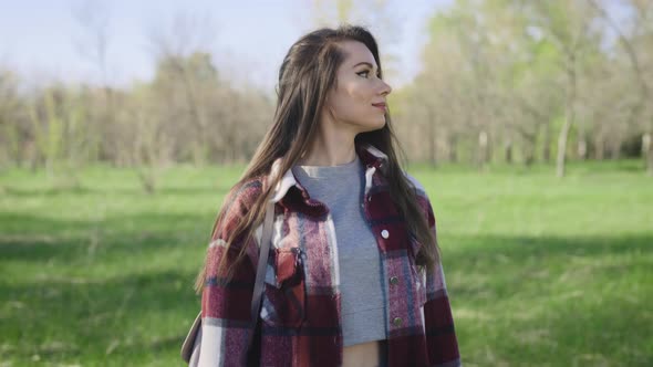 A Beautiful and Carefree Young Woman Walks in the Park in Spring