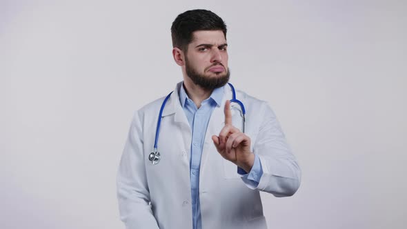 Portrait of Serious Doctor in Professional Medical White Coat Showing Rejecting Gesture Disapproving