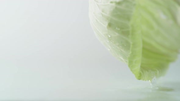 A green cabbage leaf rolling on water surface. Slow Motion.