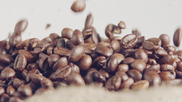 slow motion of coffee beans falling into a burlap sack