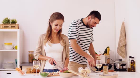 Couple Cooking Food and Drinking Wine at Home