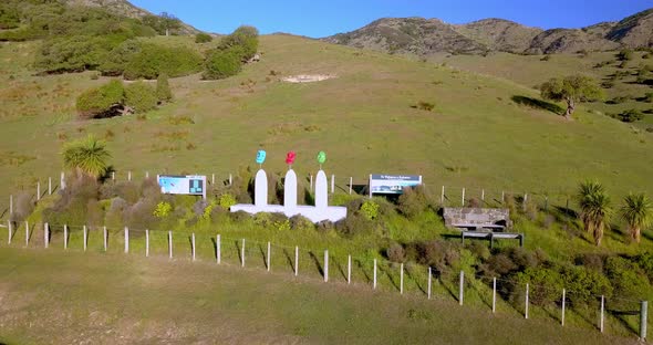 Information signboards and artistic installation of Maori Masks welcome visitors to the Port Levy ar