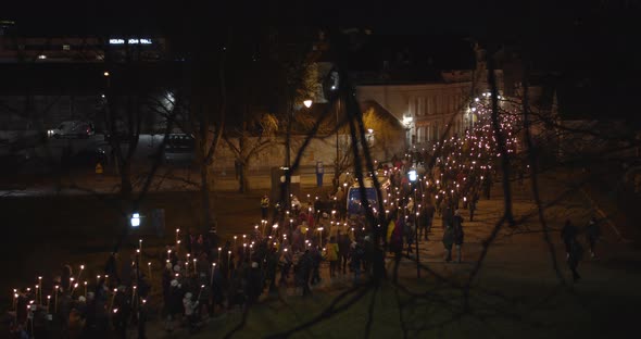 Crowd of People Walking with Burning Torches at Night on Torchlight Procession