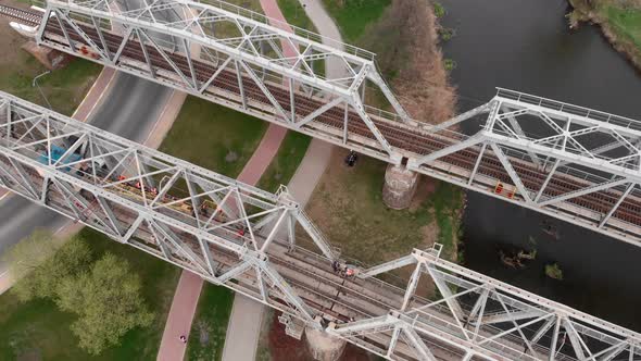 Railway bridge restoration. Rails renovation. Heavy machines on construction site.