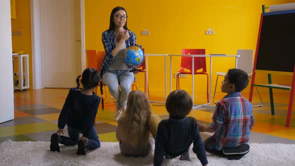 Preschool Teacher Teaching Kids About Globe