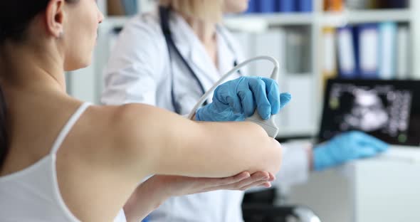 Doctor Conducts Ultrasound Examination of Patient Elbow in Clinic