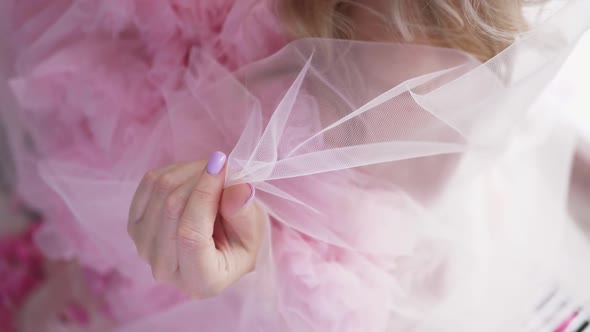 Fashionable Woman in Pink Dress and Mesh is Sitting By the Window with Purple Nail