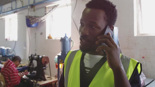 Mixed race man phoning in factory