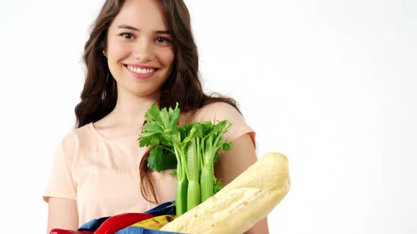 Portrait of smiling woman holding a grocery bag