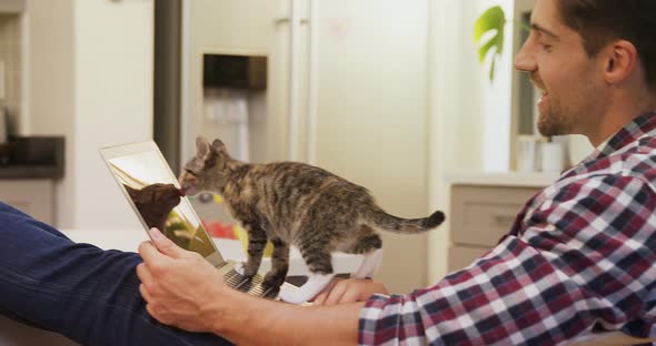 Young man showing laptop to his pet cat 4K 4k