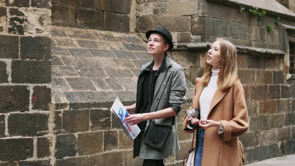 Beautiful and Style Friends Walking with Map and Camera Through the Street