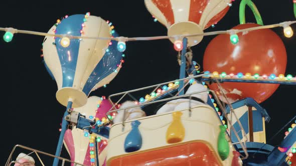 Colorful Flashing Carousel Light at the Christmas Market and Happy People Enjoying Their Holidays